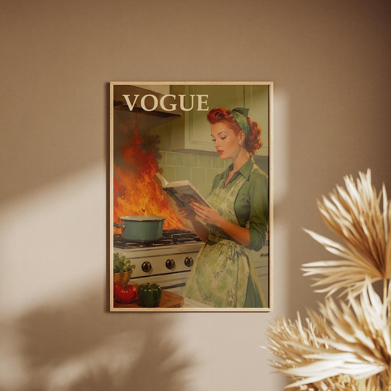 Peut inclure: Une affiche encadr&eacute;e avec une illustration de style vintage. L'image montre une femme en robe et tablier verts lisant un livre de cuisine, tandis qu'une casserole sur la cuisini&egrave;re est en feu. Le mot "VOGUE" est en haut de l'affiche.