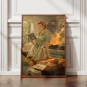 May include: A framed wall art print depicting a person with red hair wearing a green shirt and floral apron, reading a cookbook in a kitchen. A stove with flames in a pan, a glass of red wine, and a wooden cutting board with vegetables are visible.