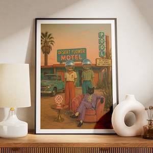 Peut inclure: Une impression d'art encadrée représentant une scène de motel dans le désert avec un camion vintage bleu sarcelle, une enseigne au néon Desert Flower Motel et un panneau Pool. Trois personnages, deux à tête de boule à facettes et un à tête de chat.
