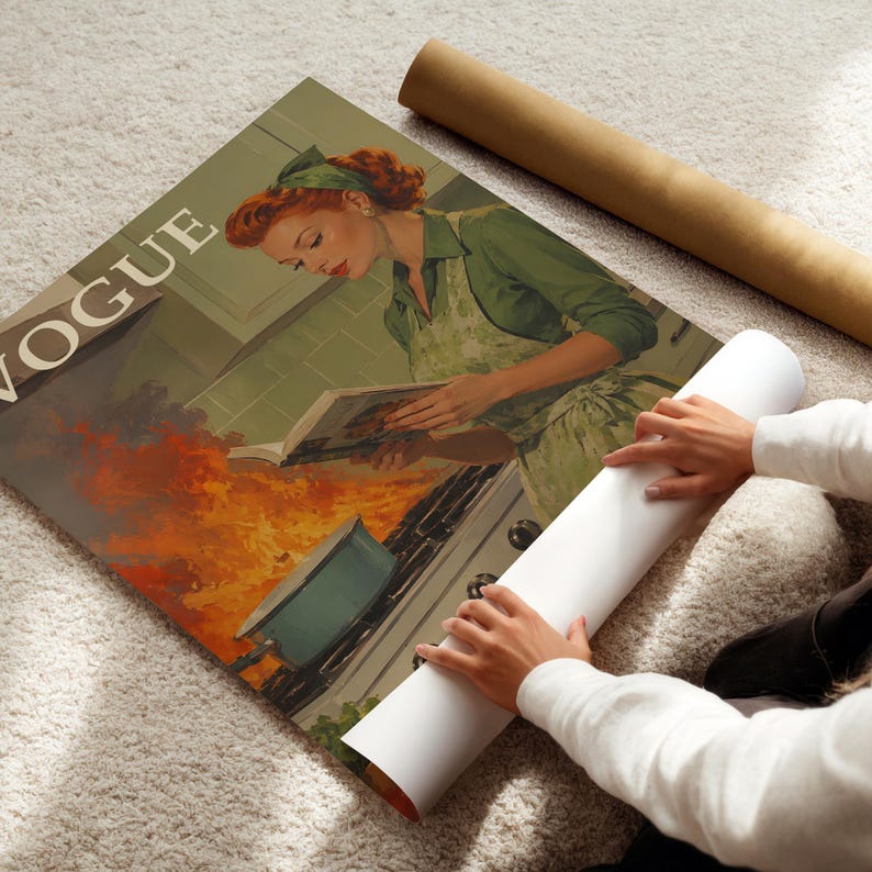Peut inclure: Une impression de couverture de magazine Vogue vintage repr&eacute;sentant une femme en robe et tablier verts, lisant un livre de cuisine dans une cuisine. L'impression a une esth&eacute;tique r&eacute;tro, avec une palette de couleurs verte, rouge et marron. Une affiche enroul&eacute;e est tenue.