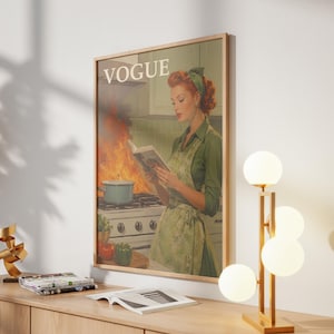 Peut inclure: Impression d'art encadr&eacute;e de style vintage avec une femme en tablier vert lisant un livre dans une cuisine en feu. Le mot "VOGUE" est en haut. Une lampe dor&eacute;e avec des globes blancs est pos&eacute;e sur une surface en bois.