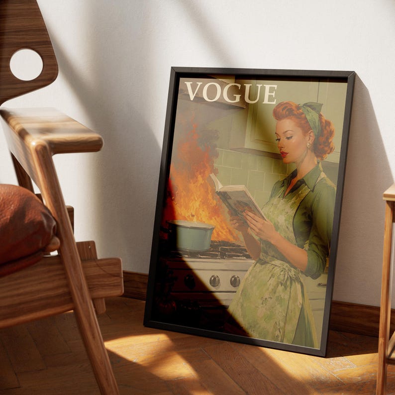 Peut inclure: Impression encadr&eacute;e d'une couverture du magazine Vogue. Elle repr&eacute;sente une femme en tablier vert lisant un livre dans une cuisine en feu. L'impression est dans un cadre noir. Le mot "VOGUE" est en haut.