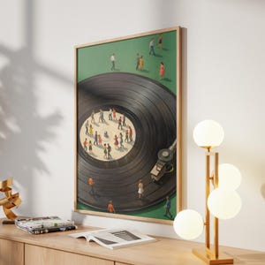 Puede incluir: Una impresi&oacute;n enmarcada que representa un disco de vinilo negro con peque&ntilde;as figuras de personas bailando sobre &eacute;l. El fondo es verde y el marco es de madera clara. Se ve un brazo de tocadiscos. La obra de arte se exhibe en un mueble de madera clara.