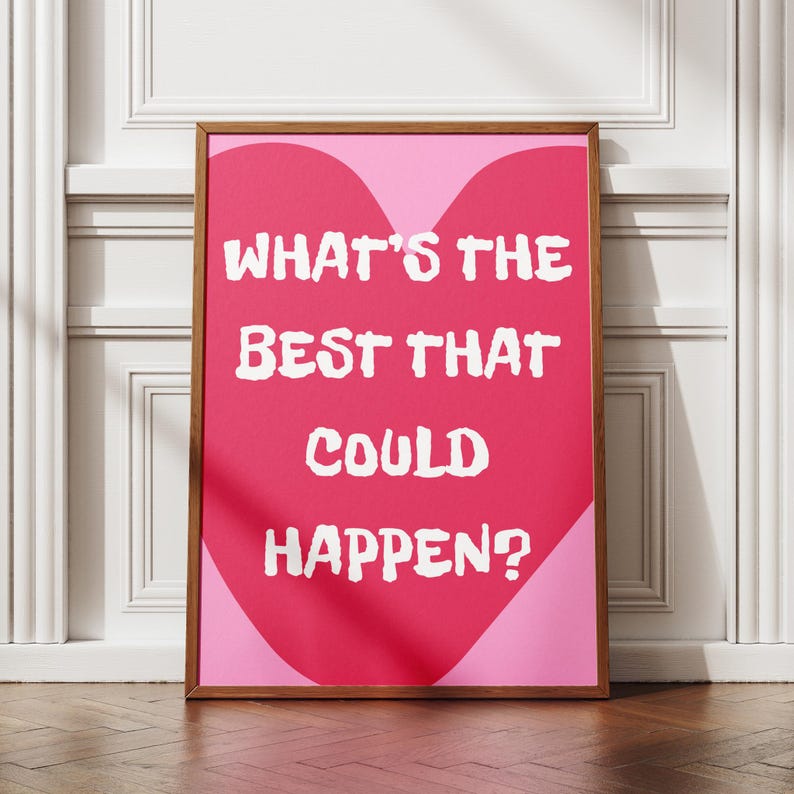 May include: A framed print with the text "WHAT'S THE BEST THAT COULD HAPPEN?" in white, set against a pink heart shape on a light pink background. The wooden frame adds a classic touch to the motivational artwork.