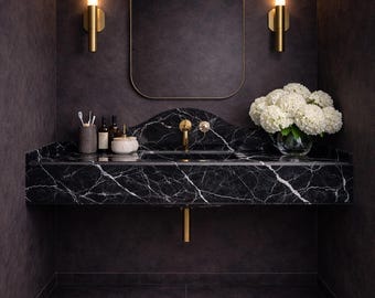 Lavabo mural de mármol negro Nero Marquina con protector contra salpicaduras integrado.