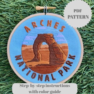 May include: Embroidered hoop art featuring the Arches National Park landscape. The design includes the words "Arches National Park" and "PDF Pattern". The text "Step-by-step instructions with color guide" is also included.
