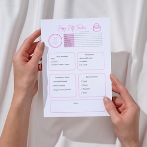 Könnte beinhalten: Ein weißes "Puppy Potty Tracker"-Blatt mit rosa Akzenten, gehalten von Händen. Das Blatt enthält Abschnitte zur Verfolgung des Töpfchenplans, der Ergebnisse, der Konsistenz und der Belohnungen. Der Titel "Puppy Potty Tracker" steht oben.