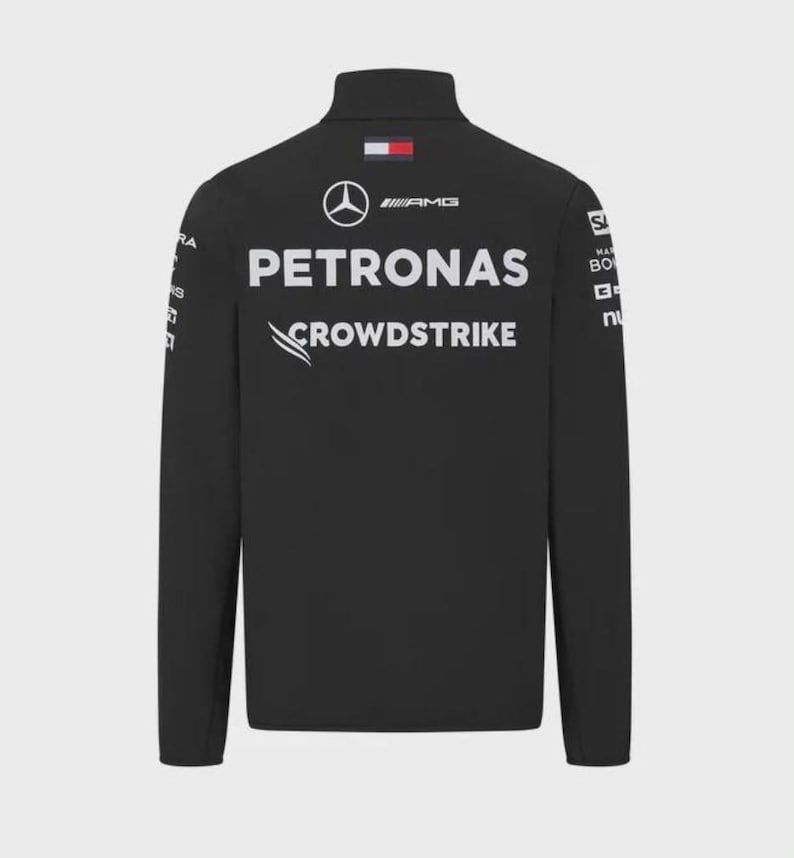 Pu&ograve; includere: Una giacca nera a maniche lunghe con i loghi Mercedes-AMG Petronas e CrowdStrike in bianco sul retro. La parte superiore della schiena presenta un piccolo emblema con la bandiera Tommy Hilfiger. Ulteriori loghi di sponsor sono stampati sulle maniche.