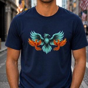 May include: Navy blue t-shirt featuring a stylized phoenix design. The phoenix has teal and orange wings and a teal body. The design is centered on the front of the shirt. The shirt is made of a soft, comfortable material.