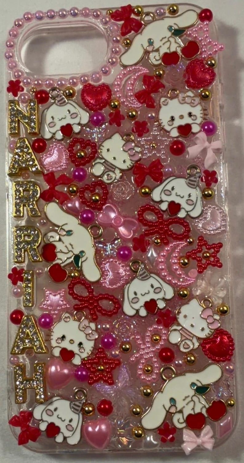 Peut inclure: Une coque de t&eacute;l&eacute;phone transparente orn&eacute;e d'&eacute;l&eacute;ments roses, rouges et dor&eacute;s. Elle pr&eacute;sente des personnages Hello Kitty et Cinnamoroll, des c&oelig;urs, des n&oelig;uds et le nom "NARAH" en lettres dor&eacute;es. Le design est compos&eacute; de perles et de breloques.