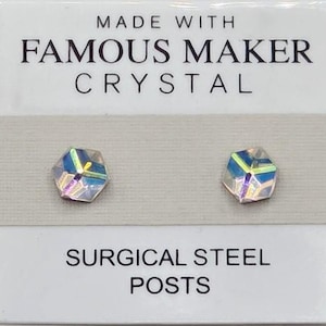 May include: A pair of iridescent crystal stud earrings. The earrings are faceted and reflect multiple colors. The card reads "MADE WITH FAMOUS MAKER CRYSTAL" and "SURGICAL STEEL POSTS".