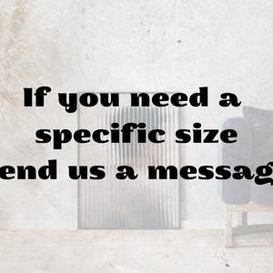 May include: Text on a white background reads, "If you need a specific size send us a message." A decorative, textured panel is behind the text. A small vase and a chair with a dark cushion are also visible.