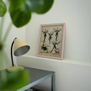 May include: A framed print with a pink border. The artwork depicts stylized figures of waiters carrying trays, a woman seated at a table, and a dog. The print is displayed on a white shelf.