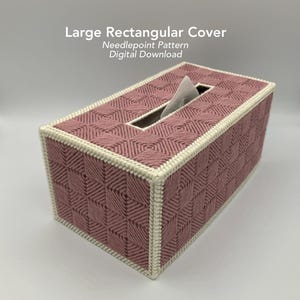May include: A rectangular tissue box cover in a dusty rose color, featuring a geometric needlepoint pattern. The cover has a cream-colored border and a rectangular opening for tissue access. The text "Large Rectangular Cover" is visible.