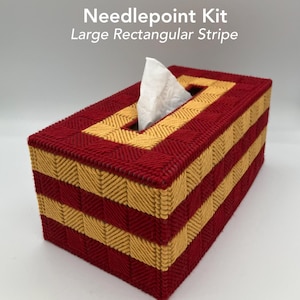 Peut inclure: Un cache-boîte à mouchoirs rectangulaire avec un motif de point de croix. Le couvercle présente des rayures alternées rouges et dorées. Le texte "Needlepoint Kit Large Rectangular Stripe" est visible. Un mouchoir blanc dépasse de l'ouverture supérieure.