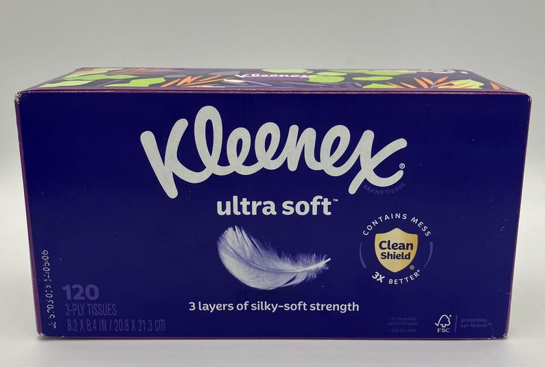May include: A box of Kleenex Ultra Soft tissues. The dark blue box features the Kleenex logo in white, the words "ultra soft", and a graphic of a feather. The box contains 120 3-ply tissues, measuring 8.2 x 8.4 inches.