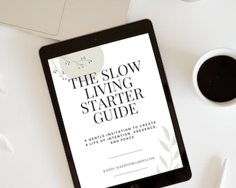 May include: A black tablet displays "THE SLOW LIVING STARTER GUIDE" with text below, including "A GENTLE INVITATION TO CREATE A LIFE OF INTENTION, PRESENCE, AND PEACE." A laptop, coffee cup, and pen are also visible on a white surface.