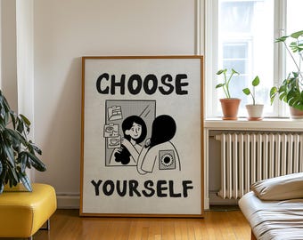May include: A framed art print with the words "CHOOSE YOURSELF" in bold black letters. The artwork features a black and white illustration of a person looking in a mirror. The mirror reflects a person holding a coffee cup. The frame is a warm brown color.