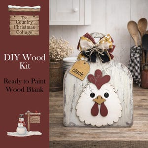 May include: A DIY wood kit featuring a ready-to-paint wood blank in the shape of a chicken. The chicken has a white face, red comb and wattle, and a wooden tag that says "cluck". The kit is decorated with a bow.