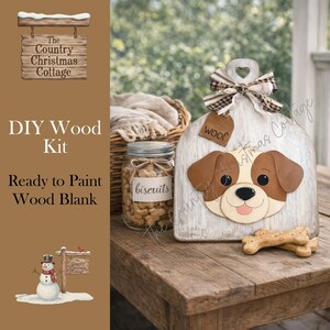 May include: A DIY wood kit with a dog-shaped wood blank, ready to paint. The dog has brown and white features, a "woof" tag, and a decorative bow. A jar of biscuits and a bone-shaped treat are also present.