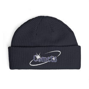 May include: Navy blue ribbed knit beanie with the word "Comets" embroidered in white and purple. The design includes a stylized comet graphic. This winter hat is a comfortable and stylish accessory.