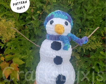 May include: A handmade crochet snowman named "Mr. Buttons" with a blue and purple hat and scarf. The snowman has a yellow nose, black button eyes, and black button accents. The image includes the text "PDF PATTERN ONLY".