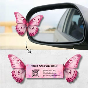 May include: A pink butterfly car mirror accessory with a business card design. The business card has the text "YOUR COMPANY NAME", a QR code, and contact information. The butterfly wings are a gradient of pink.