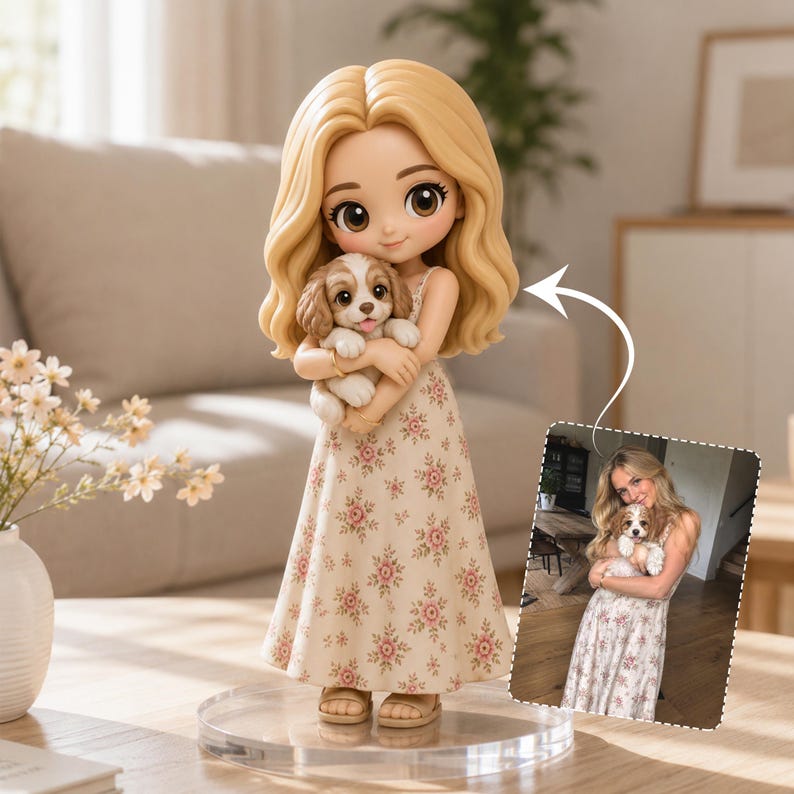 May include: A custom figurine featuring a blonde character with wavy hair wearing a cream-colored dress with a pink floral pattern, holding a small brown and white puppy. An arrow points to a photograph showing a person holding a similar puppy.