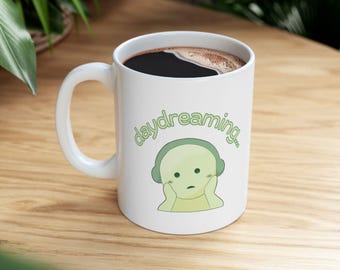 Taza con personaje verde "Soñador" / Ilustración caprichosa de Smiski, pieza de cerámica coleccionable para café.