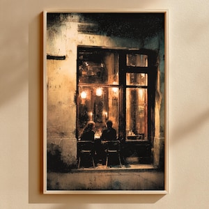 May include: Framed art print depicting a nighttime cafe scene. Two figures are seated at a table inside, illuminated by warm interior lighting. The exterior features a textured, aged facade with a dark, inviting doorway and window.