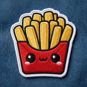 May include: Embroidered patch featuring a smiling cartoon french fry design. The fries are yellow, contained in a red carton with a cute face, outlined in black and white. A fun accessory for jackets, bags, or other fabric items.