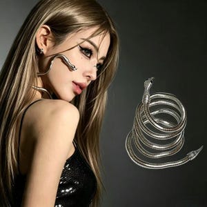 May include: A silver-toned metal snake accessory designed to coil around the body. The piece features a textured, segmented body with a detailed head and a tapered tail, showcasing a flexible, spiraling form that mimics a coiled serpent.