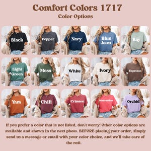 May include: A display of Comfort Colors 1717 t-shirts in various colors, including black, navy, and white. Each shirt is shown on a model, with color names like "Yam" and "Orchid" displayed. The text encourages customers to inquire about additional color options.