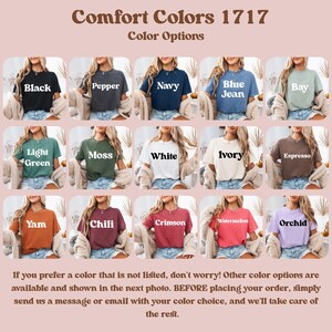 May include: A display of Comfort Colors 1717 t-shirts in various colors, including black, navy, and white. Each shirt is shown on a model, with color names like "Crimson" and "Orchid" displayed. The text encourages customers to inquire about additional color options.