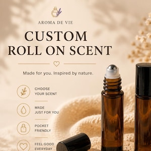 May include: Two amber glass roll-on bottles with black caps, one standing upright and one with the cap removed to reveal a metal roller ball. The text reads AROMA DE VIE, CUSTOM ROLL ON SCENT, Made for you. Inspired by nature, and various icons.