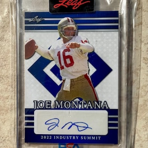 Könnte beinhalten: Eine Joe Montana Footballkarte in einer Schutzhülle. Die Karte zeigt Montana in einem weißen und roten Trikot beim Werfen eines Footballs. Die Karte trägt den Text "JOE MONTANA" und ein Autogramm. Die Karte stammt vom Industry Summit 2022.