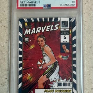 以下が含まれることがあります： 2025年Donruss WNBA Paige Bueckers Net Marvelsのトレーディングカード。PSAによるGEM MT 10評価。保護ケース入り。バスケットボールを持つBueckersの様式化された画像が、赤と白の背景に描かれています。