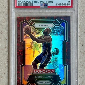 Puede incluir: Una tarjeta de baloncesto de LeBron James de la serie 2023 Prizm Monopoly, calificada. Presenta un patrón rojo y una foto de acción de James con el uniforme de los Lakers. La tarjeta está calificada como Mint 9.