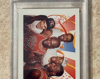 May include: A 1991 Skybox Bulls Starting Five trading card, graded and encased by PSA. The card features a photo of the Chicago Bulls team. The card is labelled #337 and is graded MINT 9.