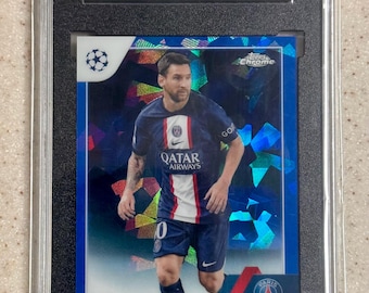 Puede incluir: Una tarjeta coleccionable Topps Chrome Sapphire UEFA Champions League 2022-23 con Lionel Messi en el uniforme del Paris Saint-Germain. La tarjeta está encapsulada en un estuche SGC negro con una calificación de 9.5 y acabado azul brillante.