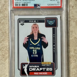 May include: A 2025 Panini Instant WNBA trading card featuring Paige Bueckers. The card shows Bueckers holding a Dallas Wings jersey with the number 25. The card is graded GEM MT 10 by PSA.