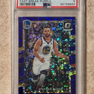 May include: A 2017 Panini Donruss Optic Stephen Curry basketball card, graded Mint 9 by PSA, encased in a protective holder. The card features a photo of Curry in his Golden State Warriors uniform. The card has a Fast Break Purple design.
