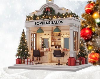 May include: A 2D flat Christmas ornament shaped like a salon, with the text "SOPHIA'S SALON". The ornament features a white facade, green lamps, and two black salon chairs. Decorated with Christmas lights, a wreath, and small Christmas trees.