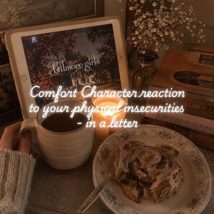 Peut inclure: Une tablette affichant l'écran titre de Gilmore Girls avec le texte Comfort Character reaction to your physical insecurities - in a letter, une tasse en céramique, une bougie allumée et un roulé à la cannelle sur une assiette à motifs floraux.