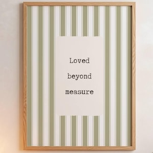 May include: A rectangular wall art print in a light wooden frame featuring a vertical sage green and white striped pattern. A central white rectangular block contains the black typewriter-style text that reads Loved beyond measure.