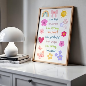This vibrant digital download features a collection of kids' daily affirmations designed to inspire confidence. The artwork includes uplifting phrases such as "I am kind," "I am brave," and "I am loved," beautifully surrounded by colorful illustrations of flowers, a sun, a rainbow, and butterflies. Perfect for decorating a child's room, playroom, or nursery, creating an uplifting environment that encourages kids to embrace a positive mindset and boosts their self-esteem.