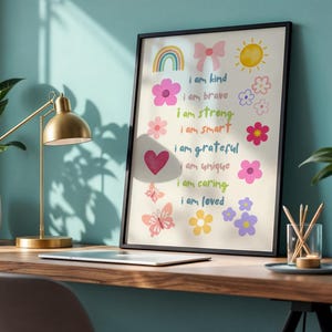 This vibrant digital download features a collection of kids' daily affirmations designed to inspire confidence. The artwork includes uplifting phrases such as "I am kind," "I am brave," and "I am loved," beautifully surrounded by colorful illustrations of flowers, a sun, a rainbow, and butterflies. Perfect for decorating a child's room, playroom, or nursery, creating an uplifting environment that encourages kids to embrace a positive mindset and boosts their self-esteem.