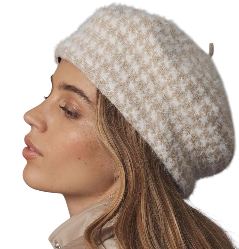 May include: A beige and white houndstooth pattern beret. The hat is made of a soft, fuzzy material. The beret is a classic style, perfect for adding a touch of elegance to any outfit. The hat is a neutral color, making it versatile for various ensembles.