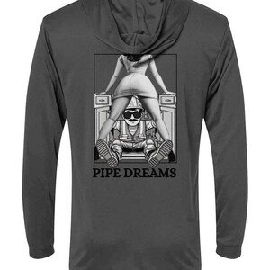 May include: Dark gray hooded sweatshirt with a black and white graphic on the back. The graphic features a cartoon image of a person with sunglasses and a woman in a dress, with the words "PIPE DREAMS" below.