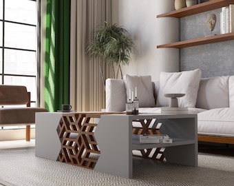 May include: A modern gray coffee table with a geometric wooden design. The table has a lower shelf for storage and is placed on a patterned rug. The room features a white sofa, wooden shelves, and green curtains.